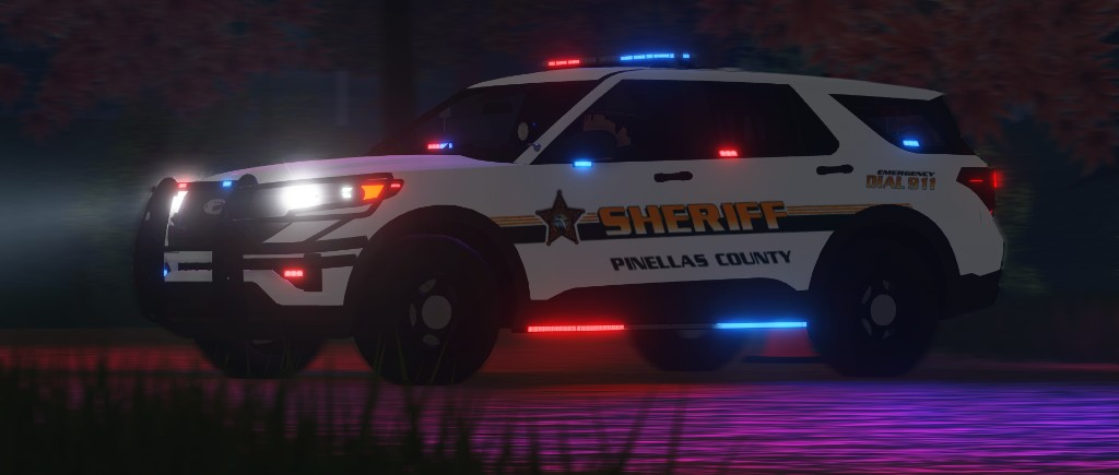 A Pinellas County sheriff SUV with red and blue emergency lights reflected on wet pavement